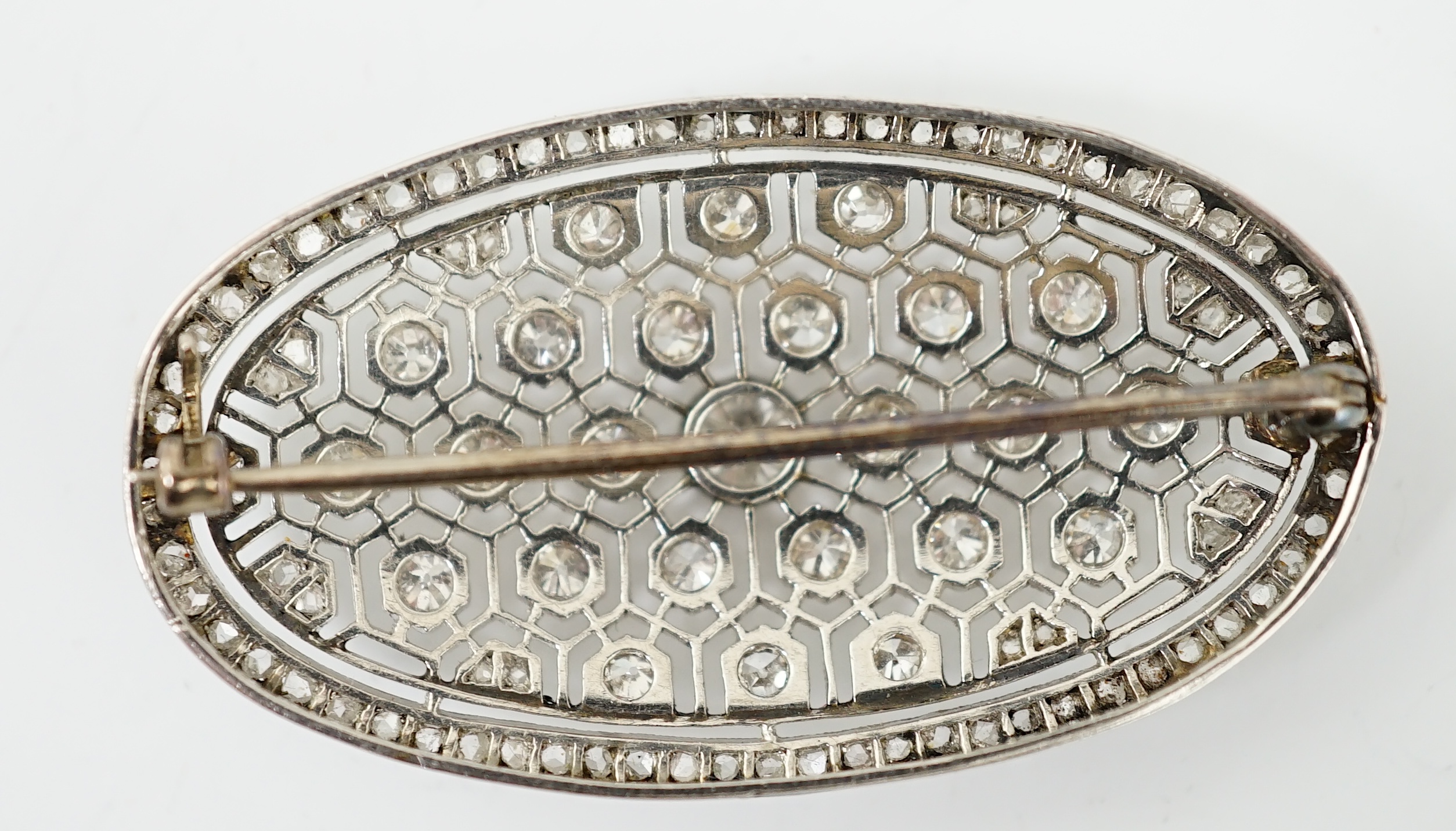 A Belle Epoque platinum and millegrain diamond cluster set oval brooch